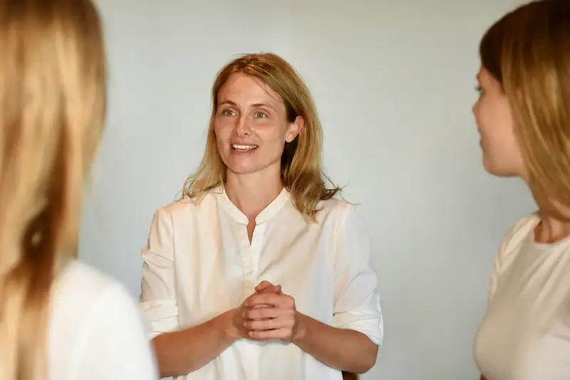 Coachin im Gespräch mit Teilnehmerin während Kommunikationstraining in ruhiger Seminaratmosphäre